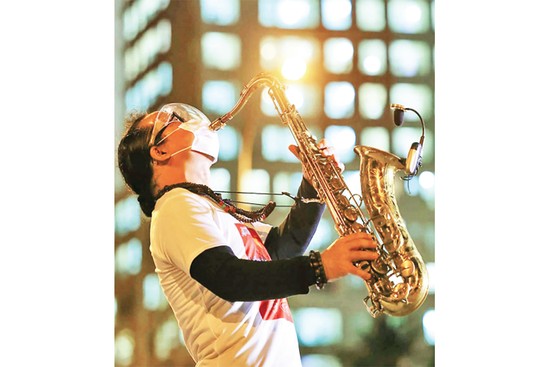 Nghệ sĩ saxophone Trần Mạnh Tuấn biểu diễn tại Bệnh viện dã chiến thu dung số 3 TP Hồ Chí Minh. Ảnh: Quỳnh Hoa 