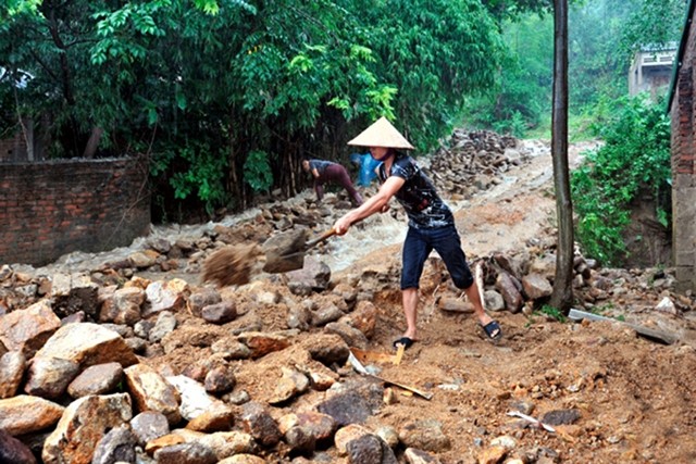 Người dân xã Tuân Lộ, huyện Sơn Dương (Tuyên Quang) thu dọn đất đá bị sạt lở do trận mưa lớn ngày 26-5 để ổn định cuộc sống.