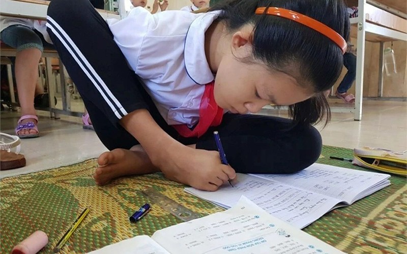 Học sinh Linh Thị Hồng ngồi viết bài trong giờ học trên lớp.