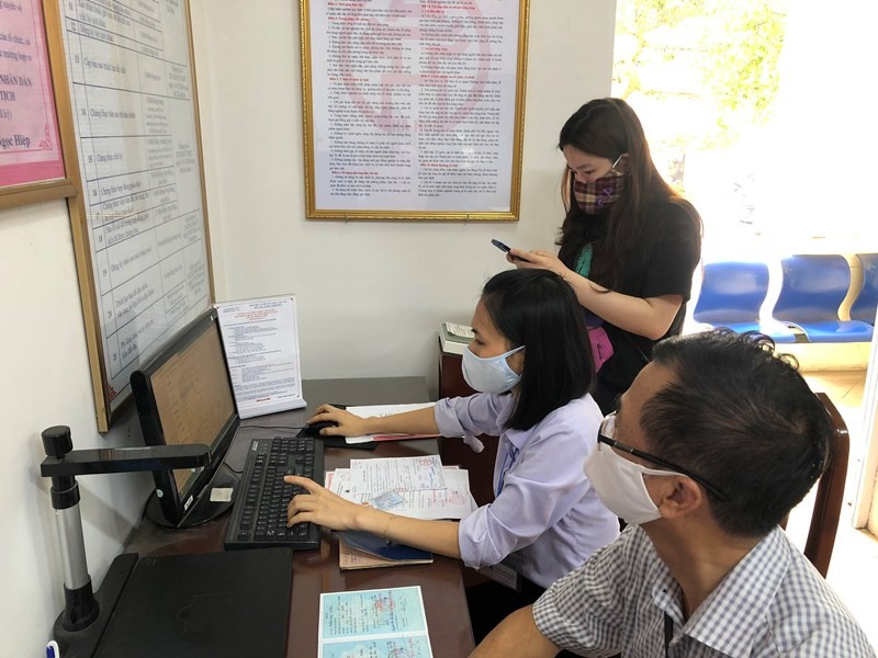 Cán bộ bộ phận một cửa phường Ngọc Lâm (quận Long Biên, Hà Nội) hướng dẫn công dân và nhập trên máy tính thực hiện dịch vụ công mức độ 3.