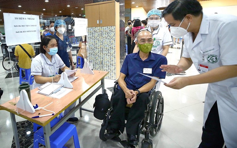 Trước khi tiêm vaccine phòng Covid-19, bác sĩ bệnh viện Bạch Mai đánh giá tình trạng sức khoẻ người khuyết tật theo phiếu sàng lọc.