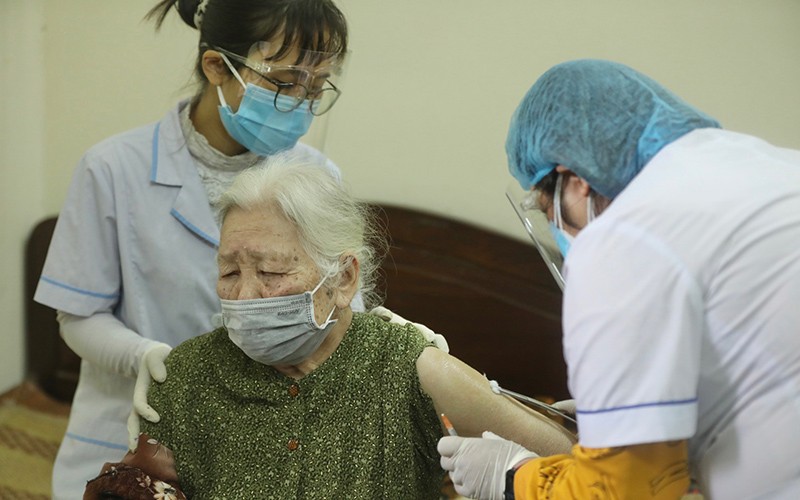 Cán bộ y tế tiêm vaccine tại nhà cho người cao tuổi tại phường Điện Biên (quận Ba Đình, Hà Nội).