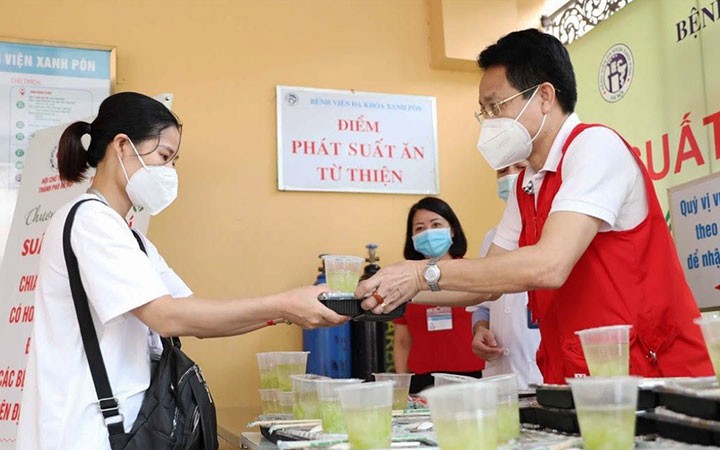Đại diện Hội Chữ thập đỏ thành phố Hà Nội tặng suất ăn cho bệnh nhân có hoàn cảnh khó khăn tại Bệnh viện đa khoa Xanh Pôn. Ảnh: THANH TÙNG