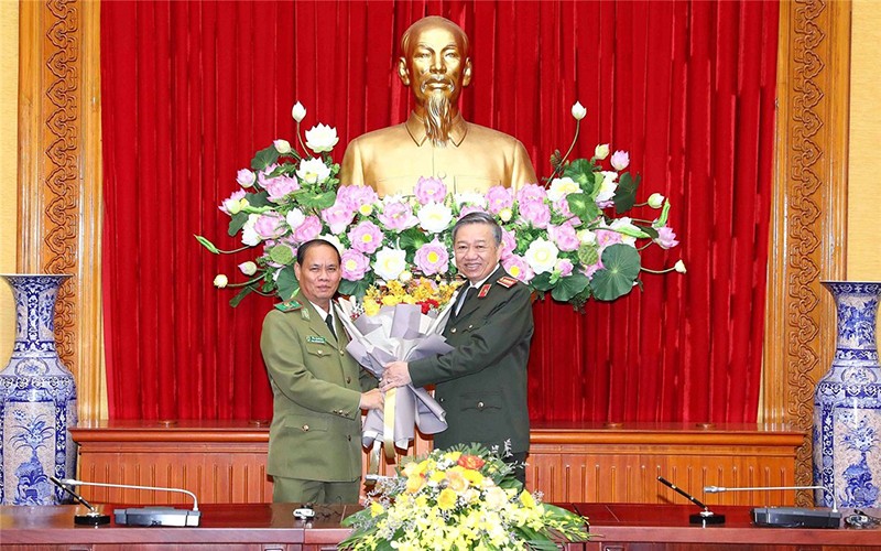 Bộ trưởng Tô Lâm tặng hoa chúc mừng Bộ trưởng Vilay Lakhamphong. (Ảnh: Bộ Công an)