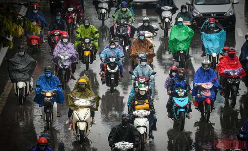 Người dân đội mưa lỉnh kỉnh đồ đạc trở về Hà Nội chiều 6/2/2022 (tức mùng 6 Âm lịch). (Ảnh: THÀNH ĐẠT)