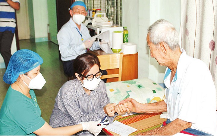 Tiêm vắc-xin tại nhà cho người già yếu, di chuyển khó khăn ở quận 10, thành phố Hồ Chí Minh trong dịp Tết.