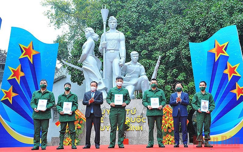 Đồng chí Nguyễn Anh Tuấn (thứ 2 từ phải sang trong ảnh) và đại diện lãnh đạo thành phố Hà Nội trao sổ tiết kiệm tặng thanh niên tình nguyện lên đường nhập ngũ có hoàn cảnh khó khăn.