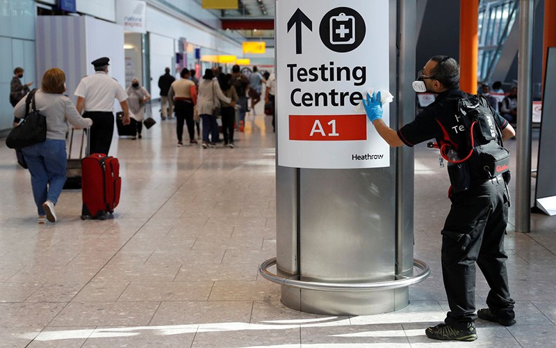 Nhân viên khử trùng biển hướng dẫn tại sân bay Heathrow, Anh, tháng 8/2021. (Ảnh: Reuters)