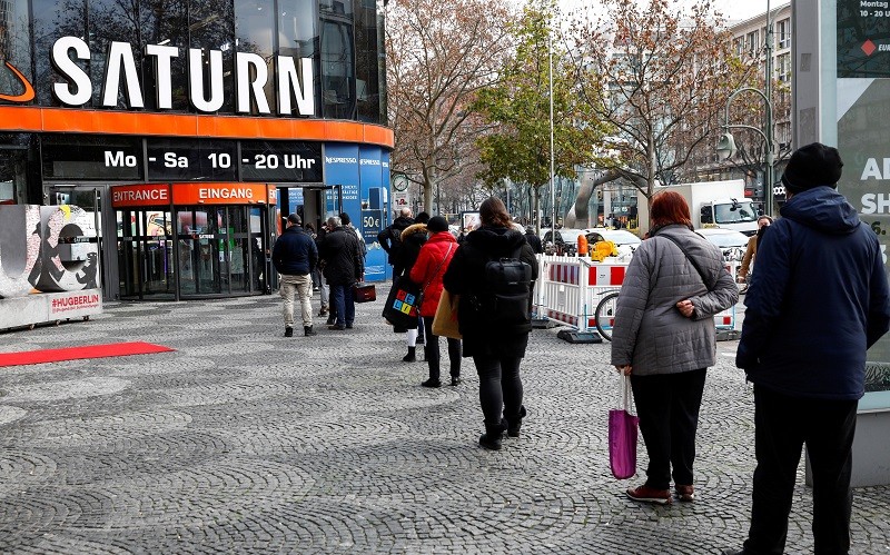 Người mua sắm xếp hàng trước cửa hàng điện tử Saturn trên đại lộ Tauentzienstrasse ở Berlin, Đức, ngày 14/12/2020. (Ảnh: Reuters)