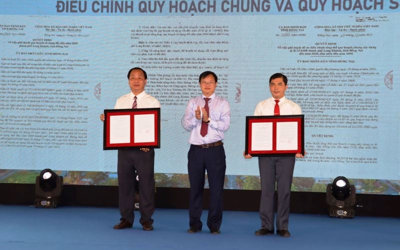 Chủ tịch UBND tỉnh Đồng Nai Cao Tiến Dũng (đứng giữa) trao quyết định phê quyệt quy hoạch xây dựng thành phố Long Khánh.