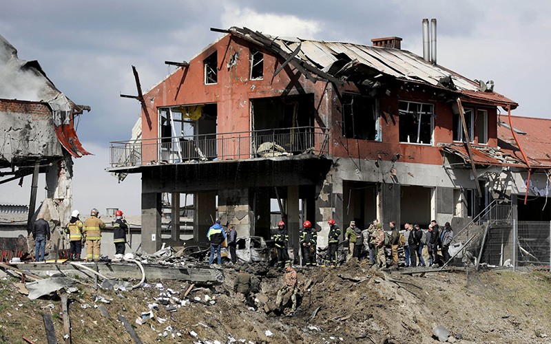 Quân nhân và lực lượng cứu hộ Ukraine có mặt tại hiện trường ngôi nhà tại TP Ukraine bị phá hủy, ngày 18/4. (Ảnh: Reuters)
