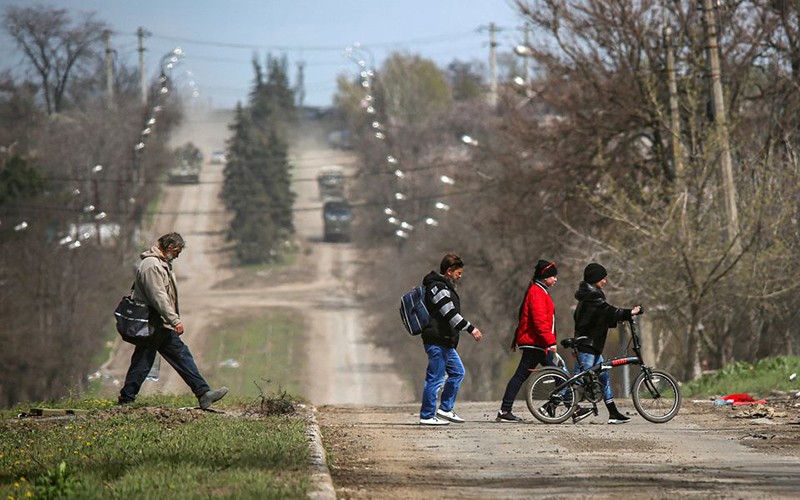 Người dân đi qua một tuyến đường tại thành phố cảng Mariupol, Ukraine, ngày 21/4. (Ảnh: Reuters)