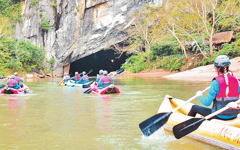 Khách du lịch khám phá động Phong Nha (Quảng Bình) bằng thuyền Kayak. 