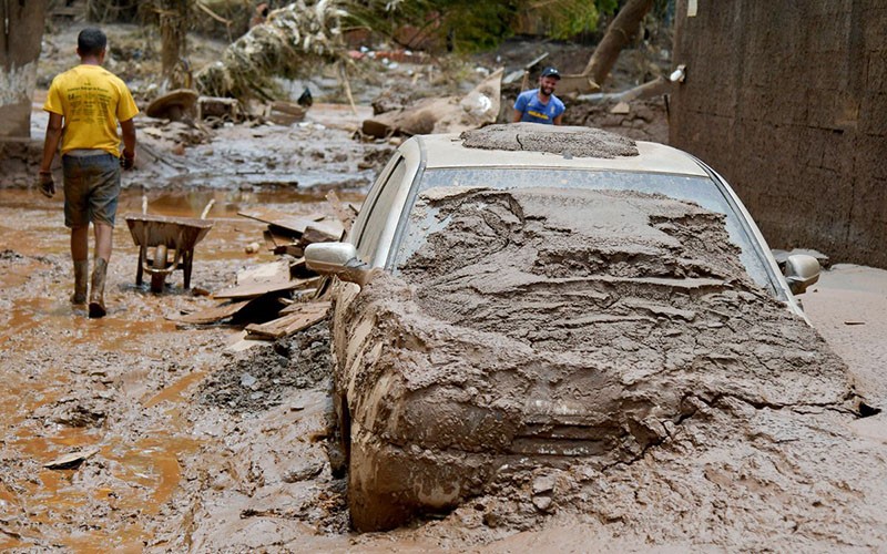 Người dân dọn dẹp đường phố sau khi xảy ra tình trạng ngập lụt tại Raposos, bang Minas Gerais, Brazil, ngày 13/1/2022. (Ảnh: Reuters)