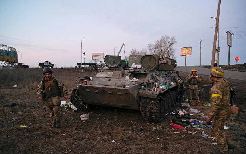 Binh sĩ Ukraine cạnh 1 chiếc xe bọc thép bị hư hại ở ngoại ô Kharkiv, Ukraine, ngày 24/2/2022. (Ảnh: Reuters)