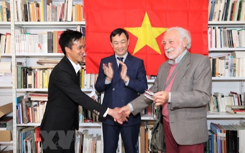 Chủ tịch Chi hội Hữu nghị Italy-Việt Nam vùng Veneto, ông Renato Darsie, trao quyền sử dụng Nhà văn hóa Việt Nam cho đại diện của sinh viên Việt Nam. (Ảnh: TTXVN)