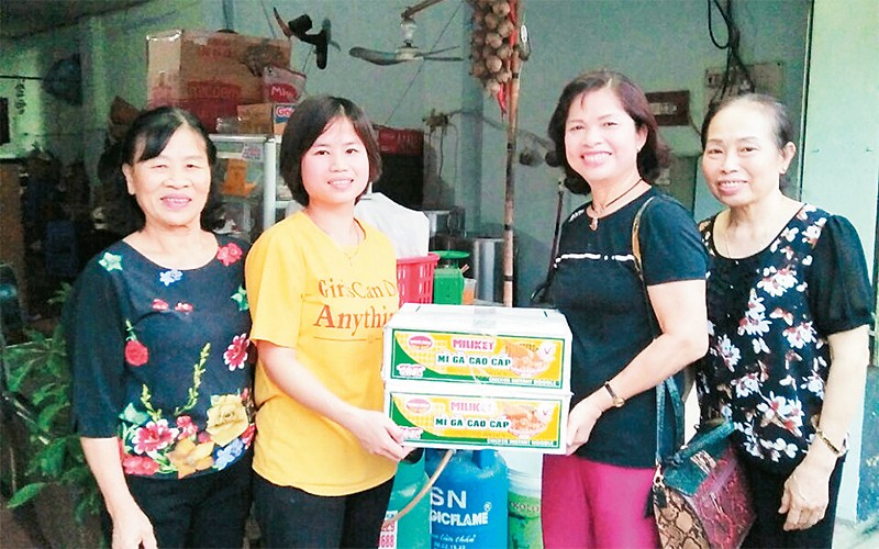 Bà Nguyễn Thị Thu Hà (thứ hai từ phải sang) tặng quà hỗ trợ các gia đình trong đợt dịch Covid-19. 