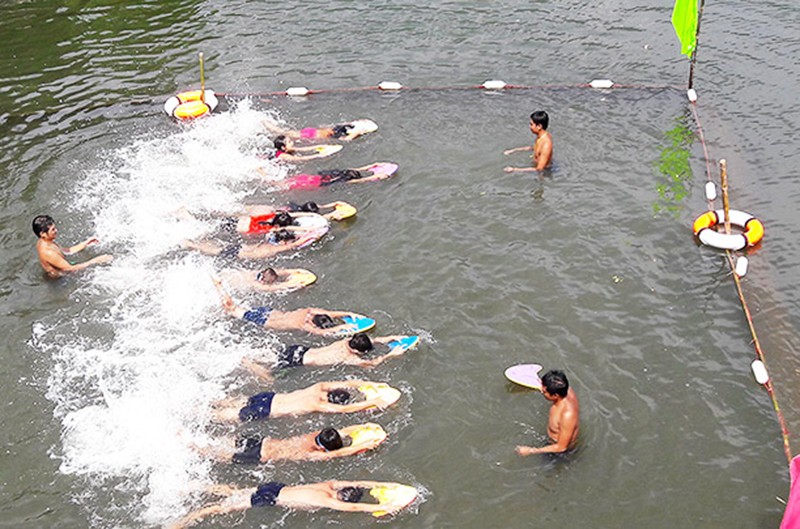 Các tình nguyện viên của tổ chức Hue Help trong một buổi dạy bơi cho trẻ em. (Ảnh: MINH ANH)