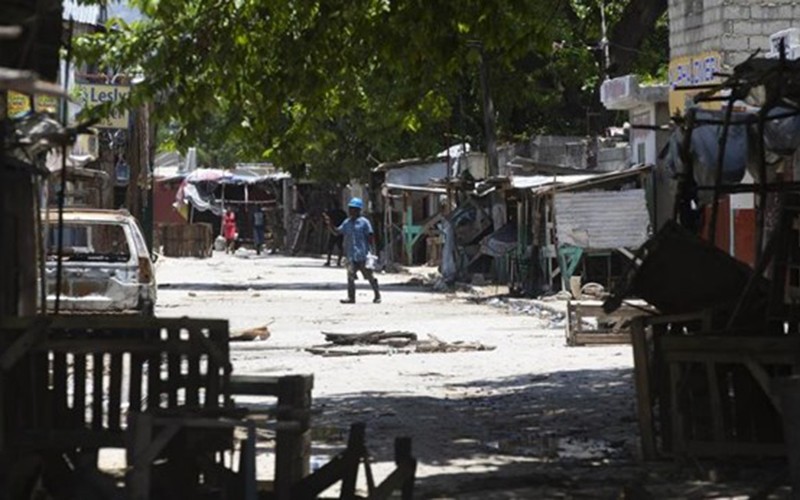 Một người đàn ông băng qua đường có rào chắn trong cuộc đụng độ giữa các băng nhóm có vũ trang ở khu phố La Plaine của Port-au-Prince, Haiti ngày 6/5/2022. (Nguồn: AP/TTXVN)