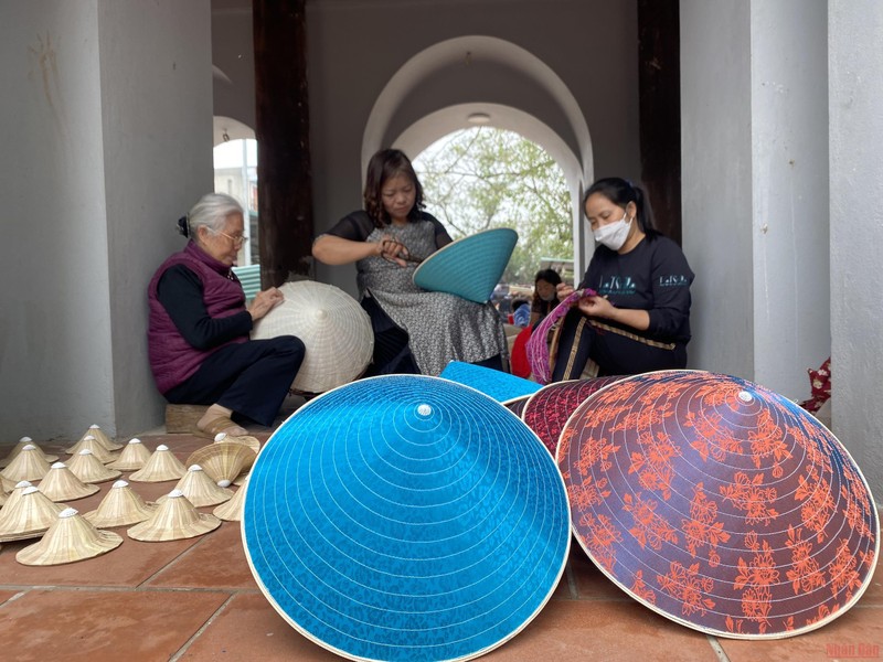 Các nghệ nhân làng Chuông gia công nón cho các diễn viên múa. (Ảnh: MINH NGHĨA)