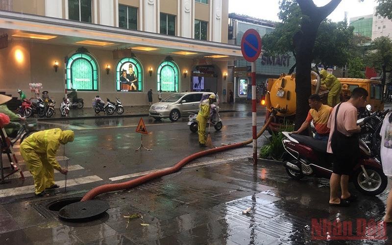 Công nhân Công ty Thoát nước Hà Nội khơi thông cống ngầm để tăng cường thoát nước trên phố Hai Bà Trưng, quận Hoàn Kiếm, Hà Nội.