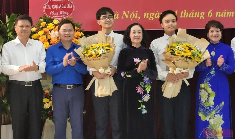 Đồng chí Trương Thị Mai tặng hoa hai đảng viên trẻ tại Trường THPT chuyên Hà Nội-Amsterdam. (Ảnh: SƠN BÁCH)