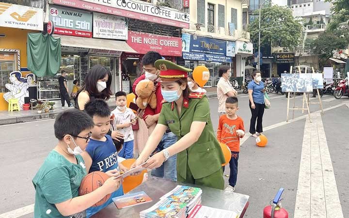 Công an quận Hoàn Kiếm (Hà Nội) phát tờ rơi tuyên truyền kiến thức về phòng cháy, chữa cháy cho trẻ em và du khách tại phố đi bộ. (Ảnh Cơ quan công an cung cấp)