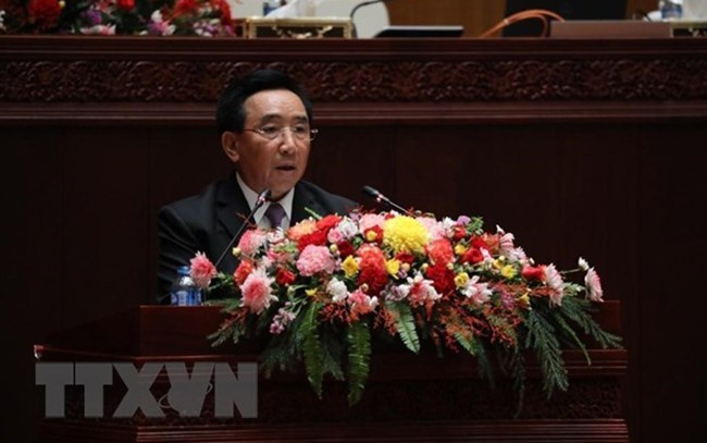 Thủ tướng Chính phủ Lào Phankham Viphavanh đọc báo cáo về tình hình thực hiện kế hoạch phát triển kinh tế-xã hội quốc gia trước Quốc hội. (Ảnh: Bá Thành/TTXVN)