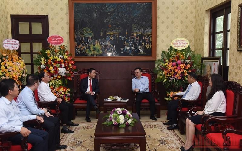 Bộ trưởng Thông tin và Truyền thông Nguyễn Mạnh Hùng chúc mừng lãnh đạo, cán bộ Báo Nhân Dân. (Ảnh: TRẦN HẢI)