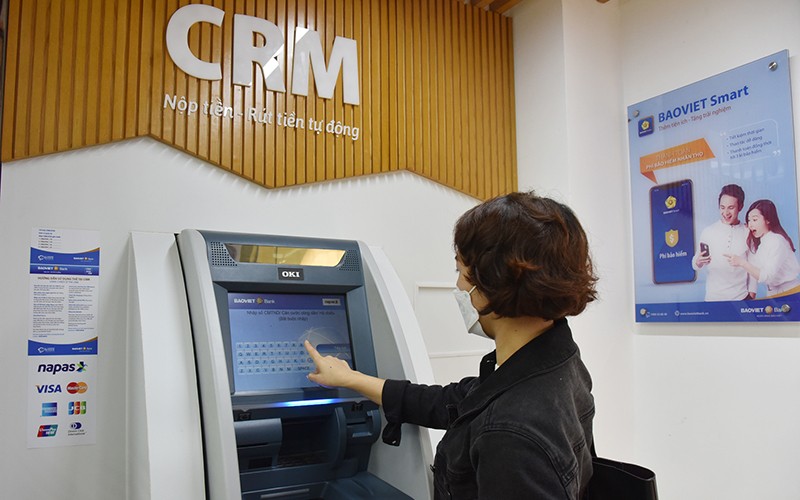 Khách hàng sử dụng dịch vụ ATM. (Ảnh: Trần Hải)