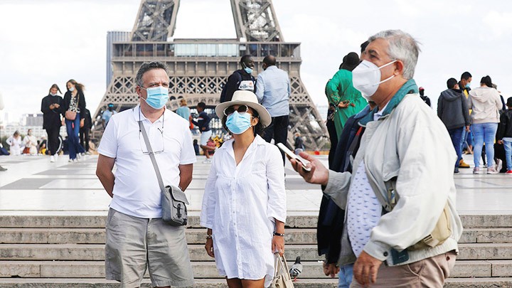 Du khách đeo khẩu trang khi tham quan tại Pháp. Ảnh: AFP
