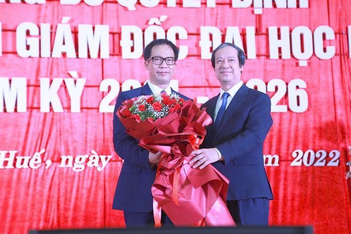 Bộ trưởng Giáo dục và Đào tạo Nguyễn Kim Sơn trao Quyết định, tặng hoa chúc mừng Giám đốc Đại học Huế Lê Anh Phương (bên trái ảnh).