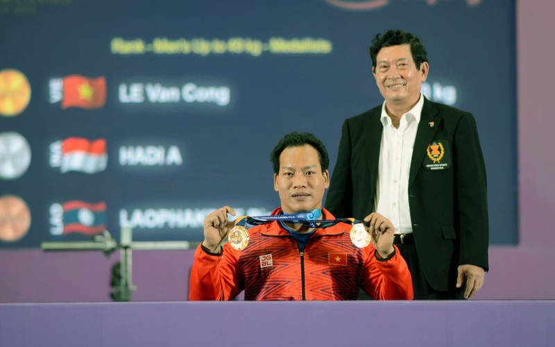 Ðô cử Lê Văn Công nhận Huy chương vàng môn cử tạ hạng dưới 49kg nam và nhận thay Huy chương vàng của đô cử Bình An (bị chấn thương) ở hạng cân dưới 54kg. (Ảnh THÁI DƯƠNG) 