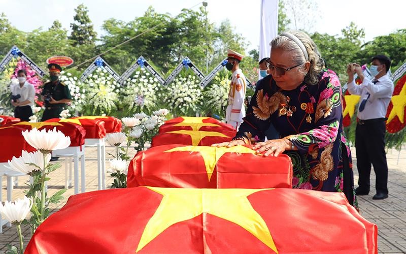 Bà Thân Thị Vân xúc động bên hài cốt đồng đội trong lễ truy điệu tại Nghĩa trang liệt sĩ huyện Nhơn Trạch (Đồng Nai).