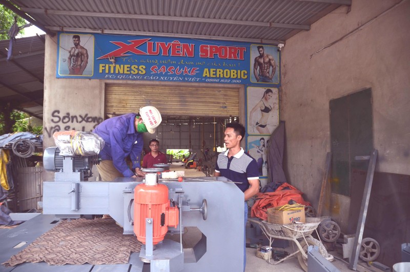 Chu Xuyên (bên phải) và chiếc máy cắt đá chuẩn bị bàn giao cho khách hàng.