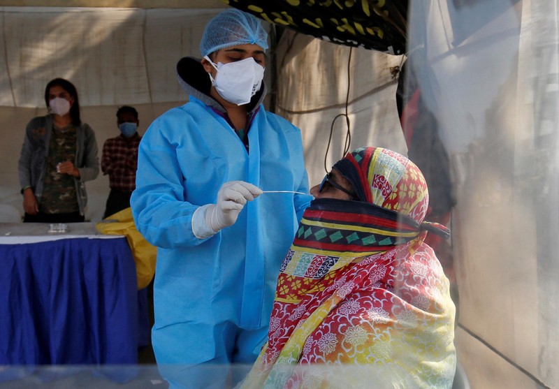 Nhân viên y tế lấy mẫu xét nghiệm Covid-19 cho người dân tại Ahmedabad, Ấn Độ. (Ảnh: Reuters)