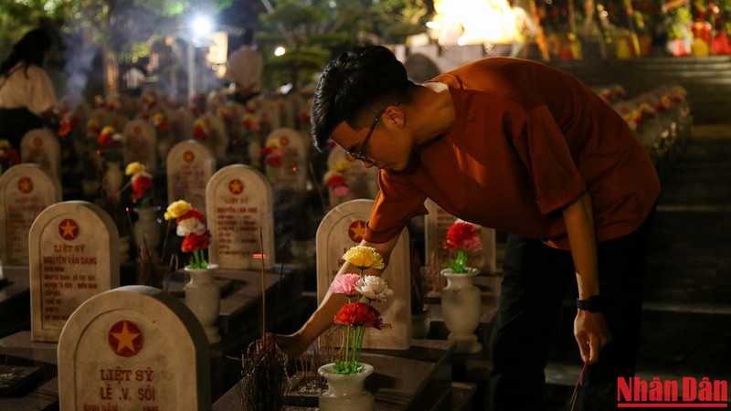 Người dân thắp hương tưởng nhớ các anh hùng liệt sĩ tại Nghĩa trang Liệt sĩ Quốc gia Trường Sơn vào buổi tối. 