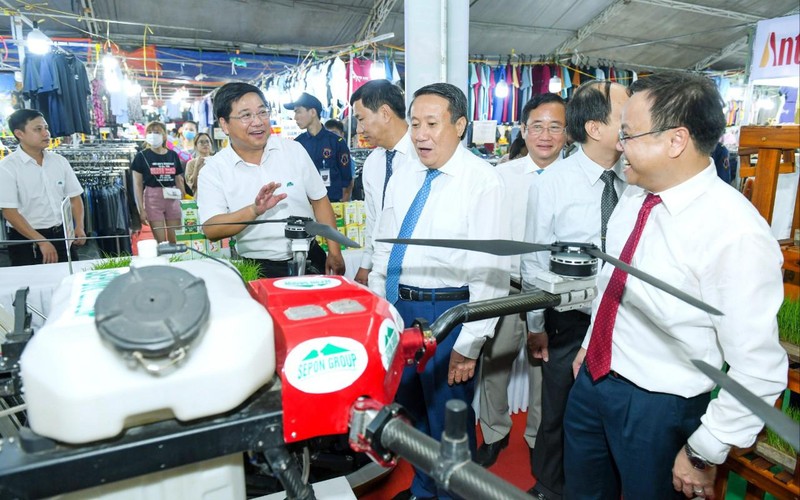 Lãnh đạo Tổng công ty Thương mại Quảng Trị giới thiệu mặt hàng máy bay không người lái phun phân bón và thuốc bảo vệ thực vật hữu cơ cho lúa với du khách và đại biểu.