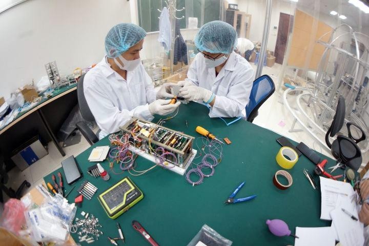 Các kỹ sư của Trung tâm Vũ trụ Việt Nam nghiên cứu vệ tinh.