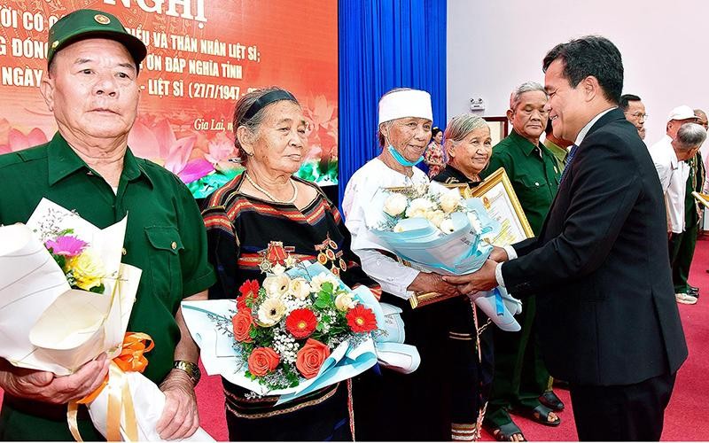 Bí thư Tỉnh ủy Hồ Văn Niên tặng hoa, bằng khen cho các đại biểu người có công và thân nhân liệt sĩ. (Ảnh: Đức Thụy)
