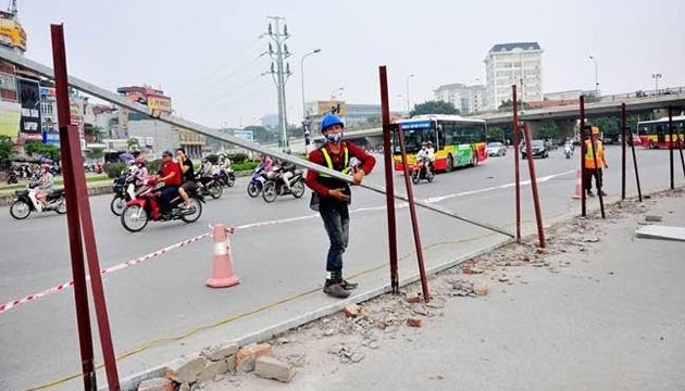 Công nhân tháo dỡ rào chắn trên tuyến đường Xuân Thủy.